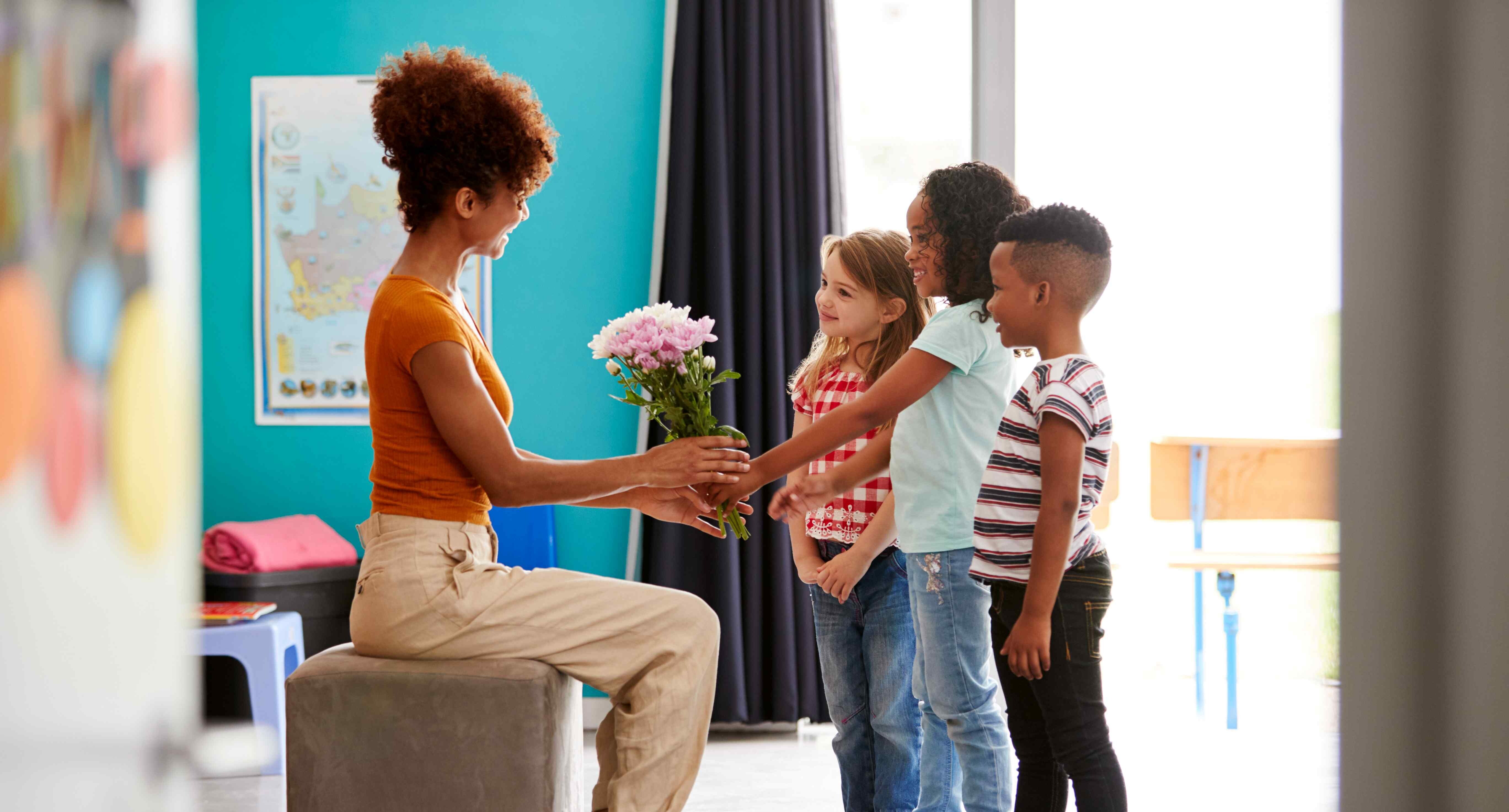 children giving flowers to teacher